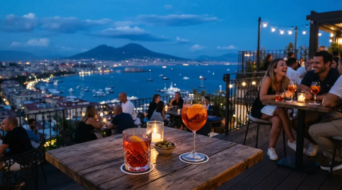 la terraza de Riserva Rooftop en Via Manzoni a la hora azul, copas de cóctel frente al panorama de la ciudad y la bahía más allá